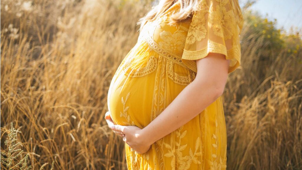 Terhes nő tartja a hasát